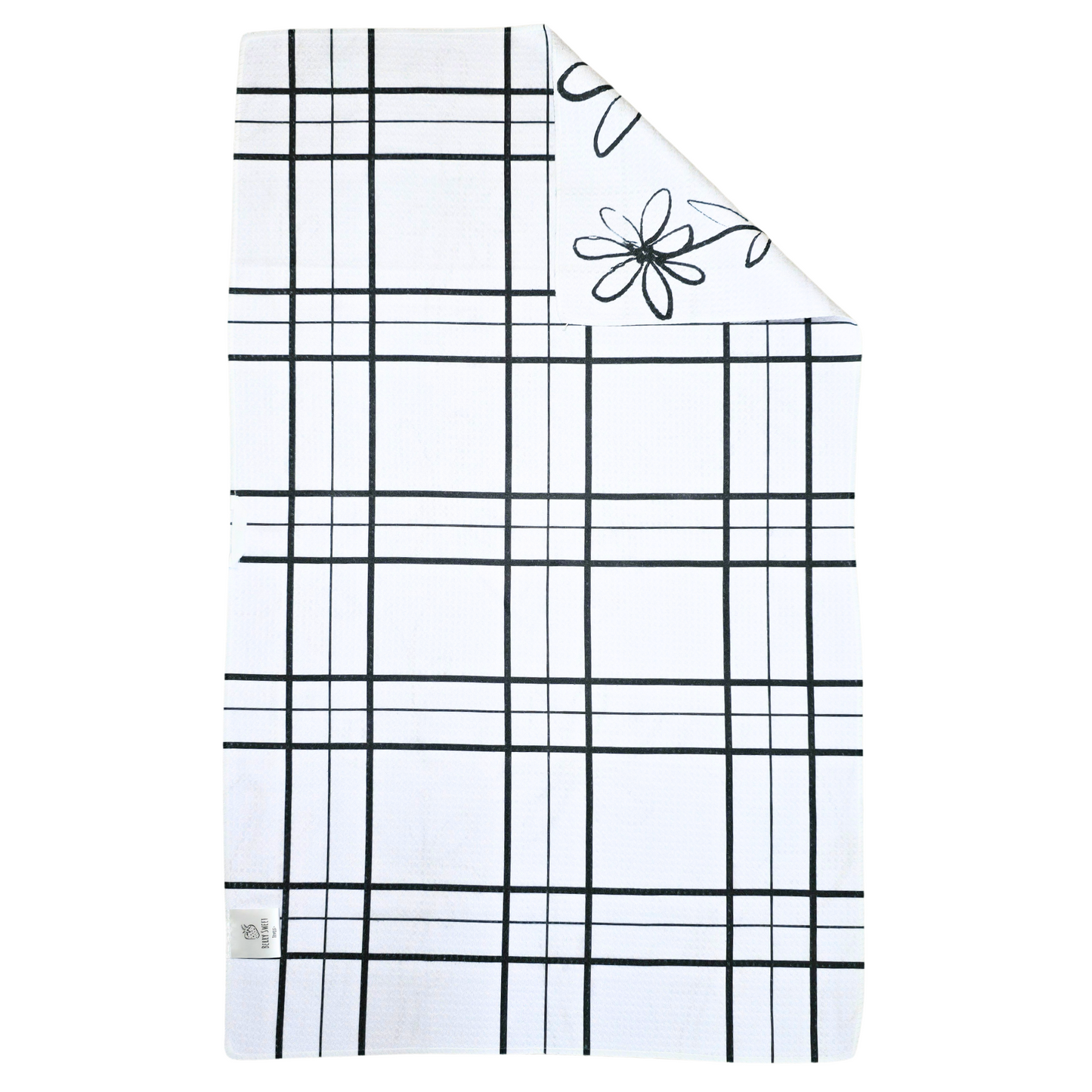 Reverse side of a double-sided waffle weave microfiber hand towel with a white background and black grid pattern, with a folded corner showing the white daisy and heart patterned front.