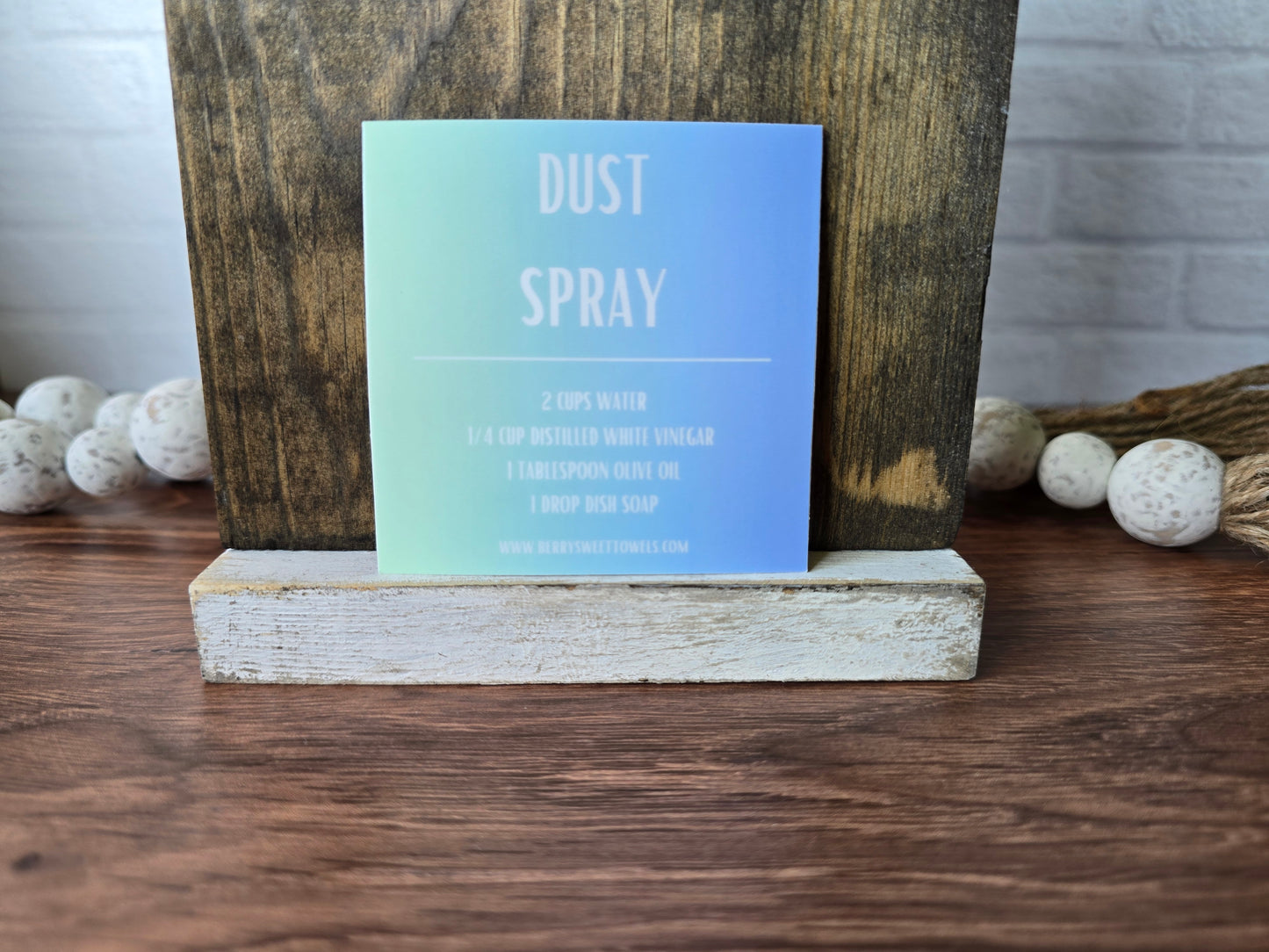 Square vinyl sticker with a green and blue background and white text labeled “Dust Spray,” displaying a DIY recipe using water, distilled white vinegar, olive oil, and dish soap.