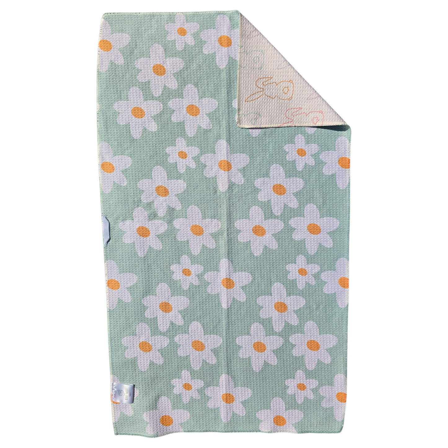 Full view of mint green reverse side with white daisy print and orange centers, corner folded to show cream-colored background featuring colored bunny outline pattern on the reverse.
