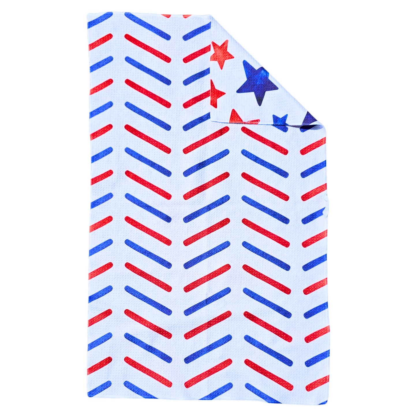 Reverse side of a double-sided waffle weave microfiber hand towel with a white background and repeating red and blue diagonal stripe pattern, with a folded corner showing the red and blue star patterned front.