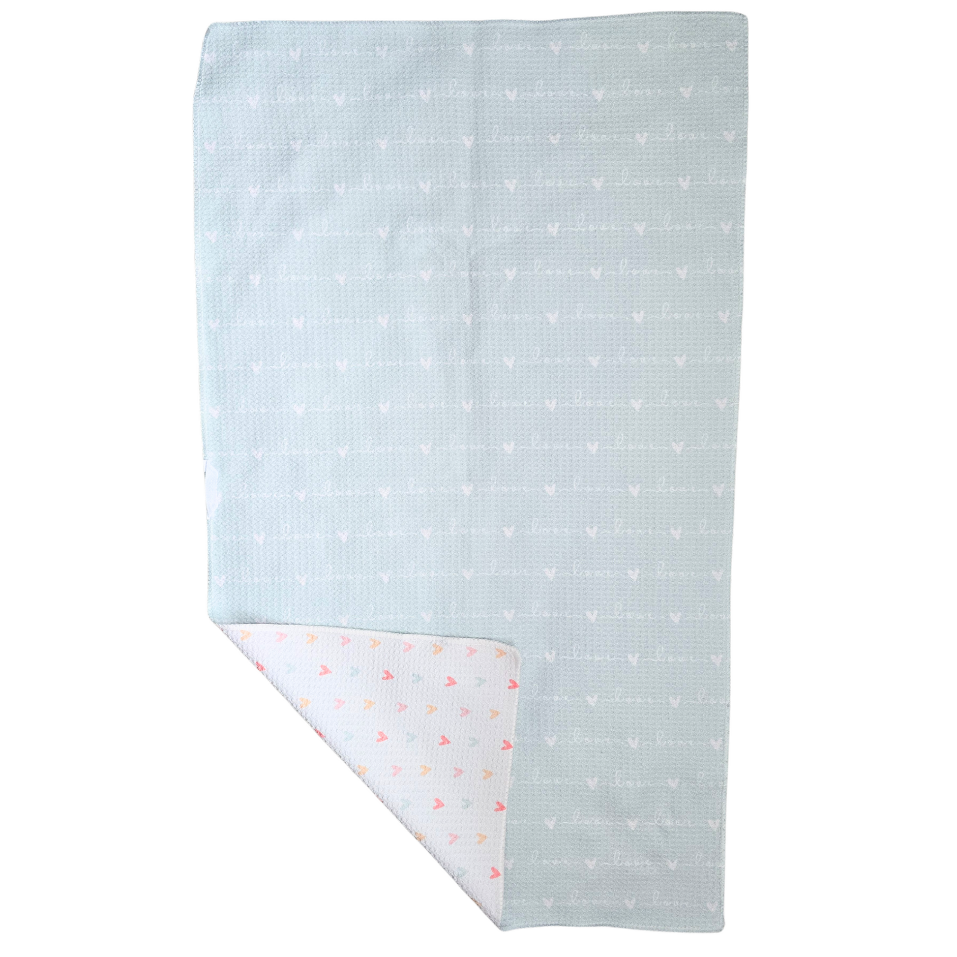 Waffle weave microfiber Towel displayed with the soft blue reverse side facing up, showing repeating “love” text and small hearts, with a folded corner revealing the white front patterned with multicolored hearts.