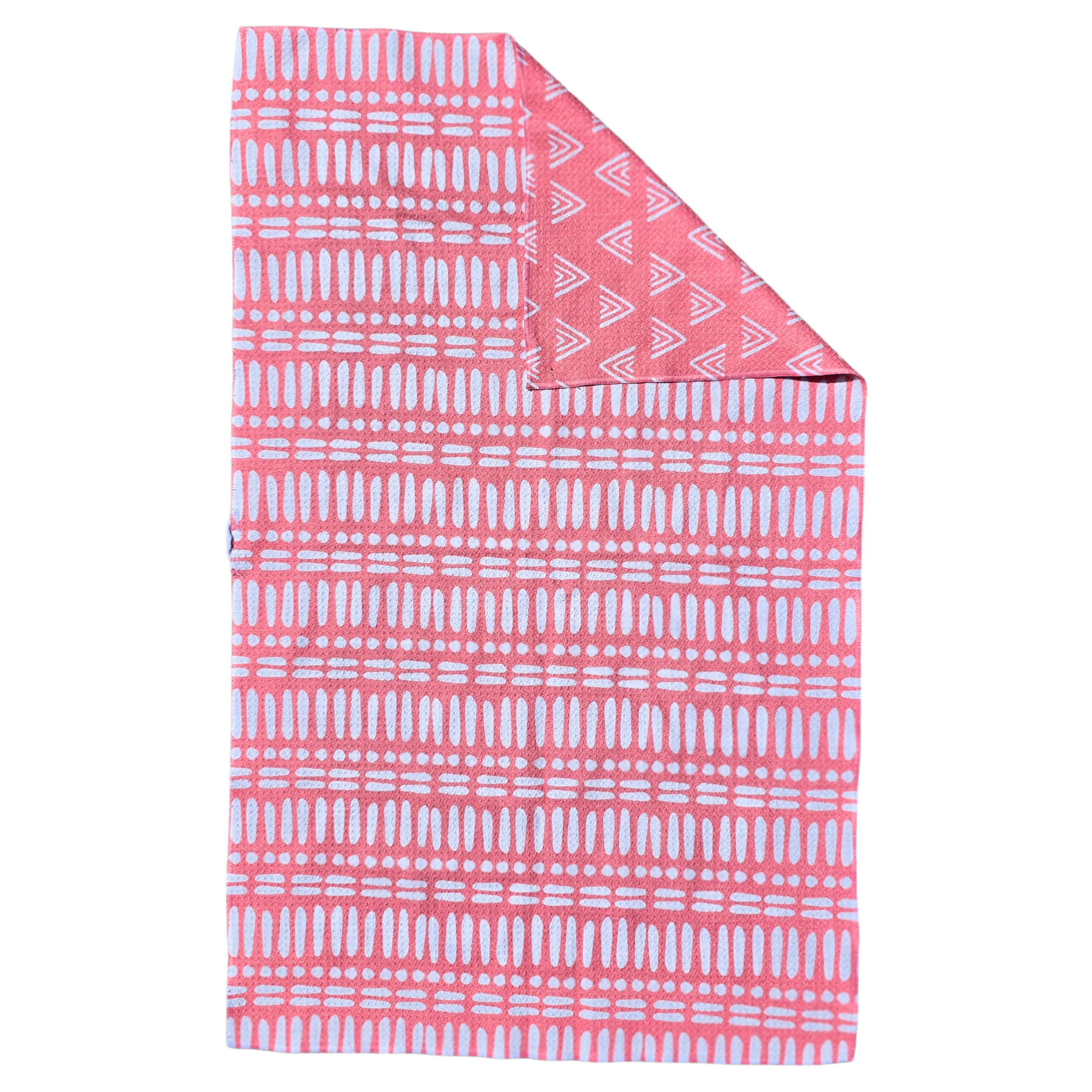 Bright pink waffle weave microfiber hand towel laid flat, showing the front with white linear and dot geometric patterns and a folded corner revealing the reverse side with white triangle geometric pattern.