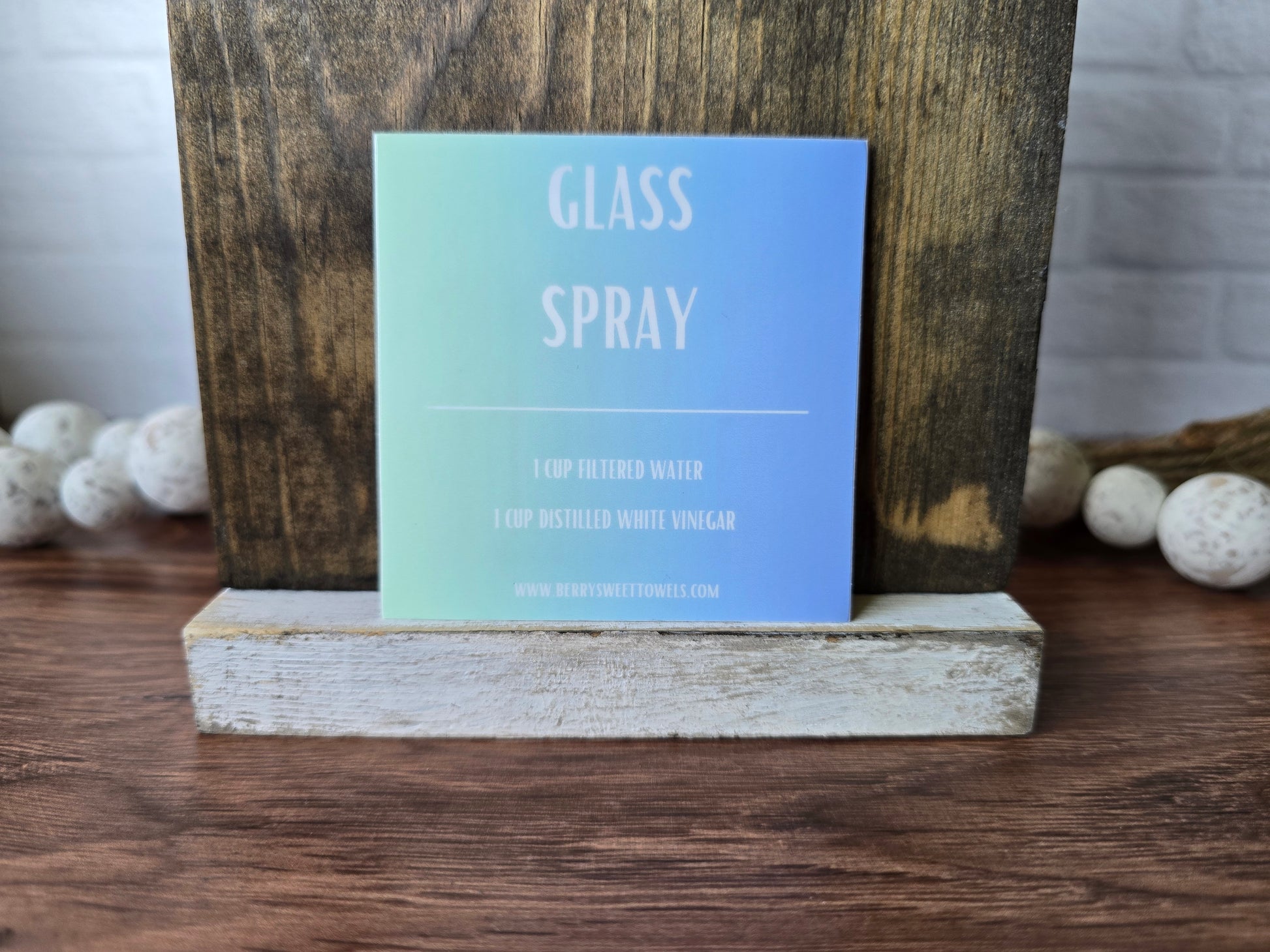 Square vinyl sticker with white text on a green and blue background labeled “Glass Spray,” featuring a DIY recipe using 1 cup filtered water and 1 cup distilled white vinegar.