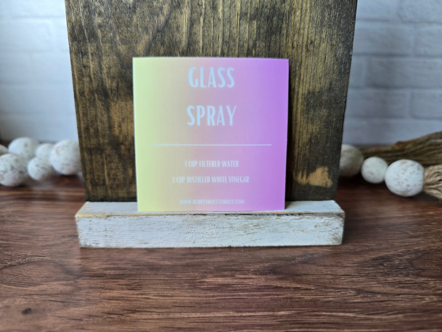 Square vinyl sticker with white text on a yellow and pink background labeled “Glass Spray,” featuring a DIY recipe using 1 cup filtered water and 1 cup distilled white vinegar.