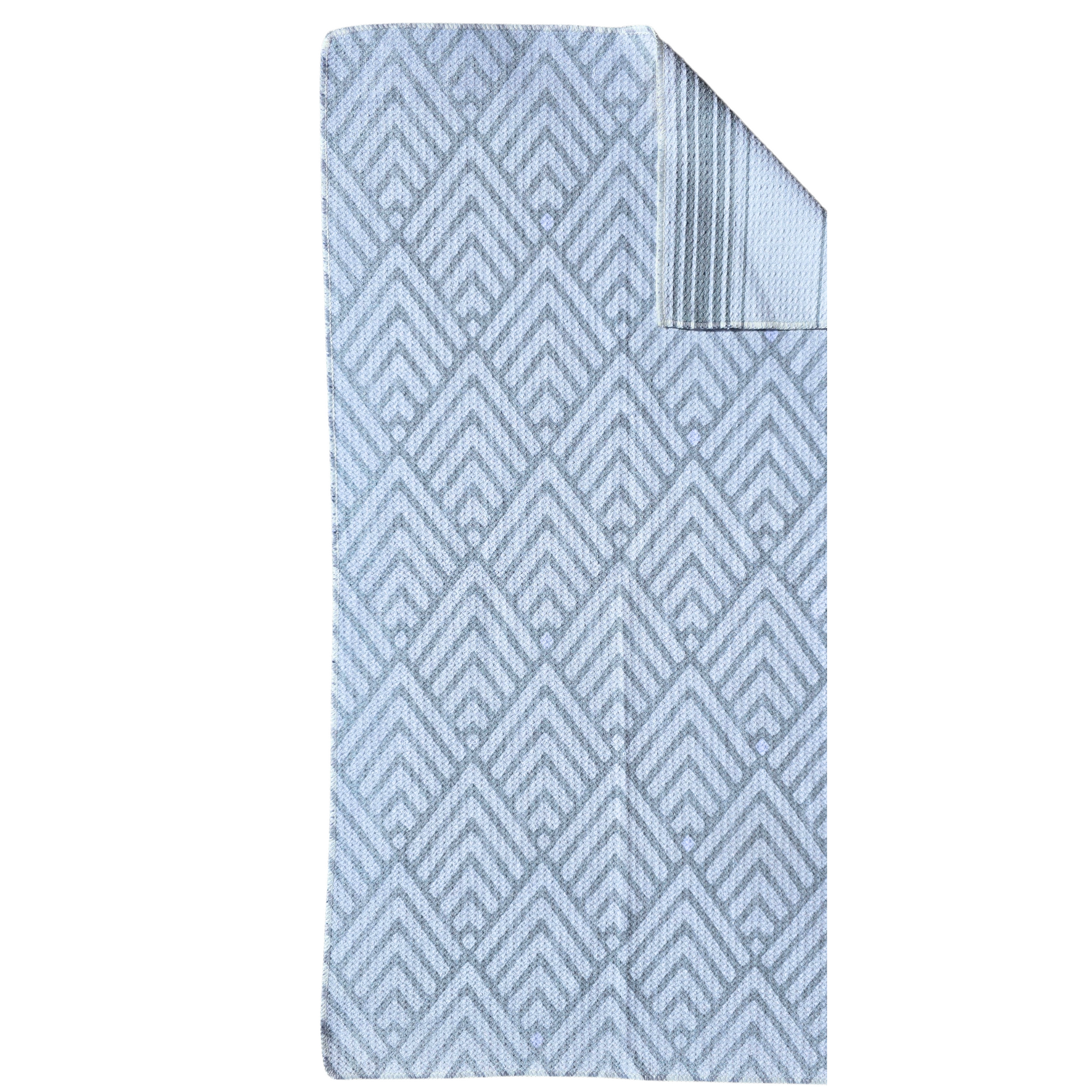 Full view of a waffle weave microfiber hand towel with light gray and white geometric patterned front and folded corner showing the gray and white striped reverse side.