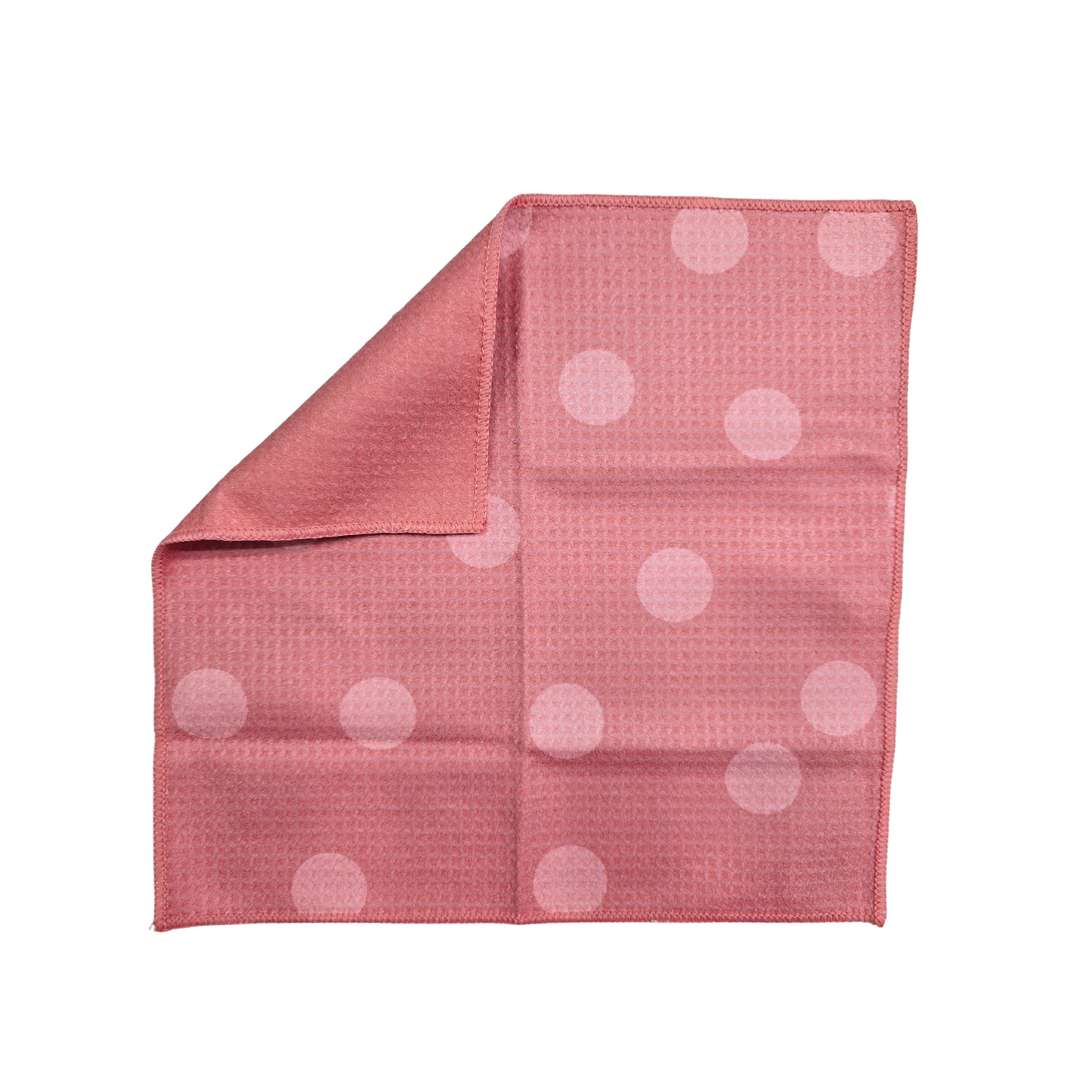 Pink waffle-weave microfiber washcloth with light pink polka dot pattern on the front and corner folded over to show the solid pink back, shown on a white background.