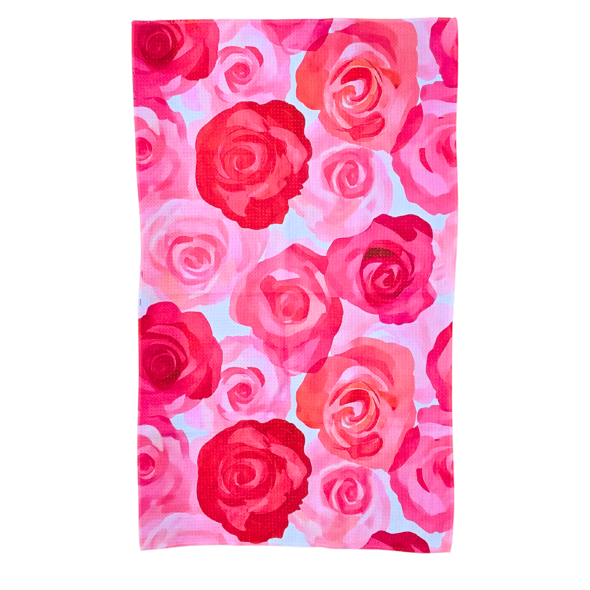 Full front view of a waffle weave microfiber hand towel with a pink, peach, and red rose floral pattern on a light background. 